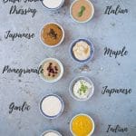 An overhead shot of a 9 small dip bowls of tahini dressing in different flavours