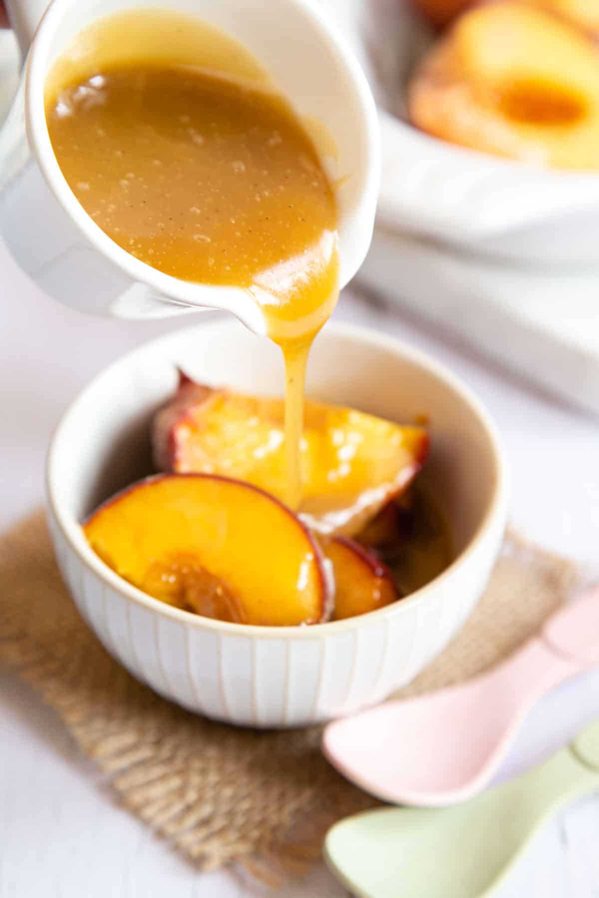 Drizzling creamy butterscotch sauce over hot roast peaches.