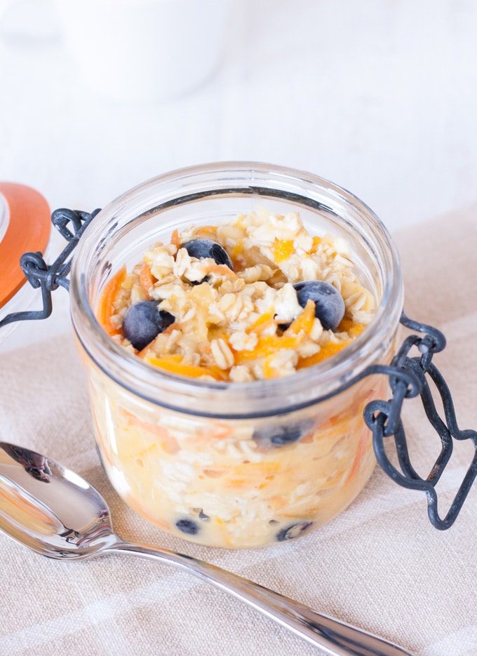 An open kilner jar filled with bircher muesli and topped with blueberries for a grab and go breakfast.