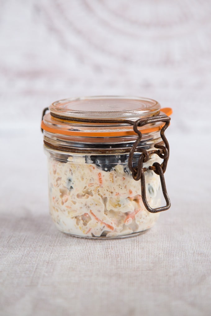 A kilner jar filled with bircher muesli and topped with blueberries for a grab and go breakfast. 