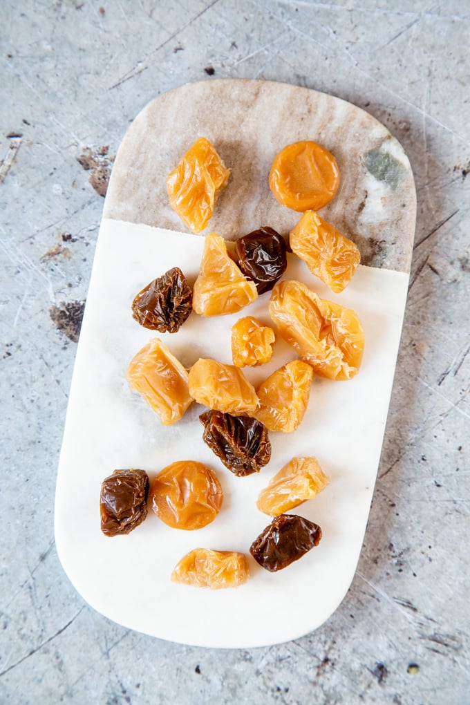 A top down view of toffees on a marble chopping board 