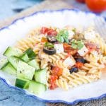 A plate of Greek salad pasta and cucumber. Pasta sauce made with olives, tomato, feta and onion
