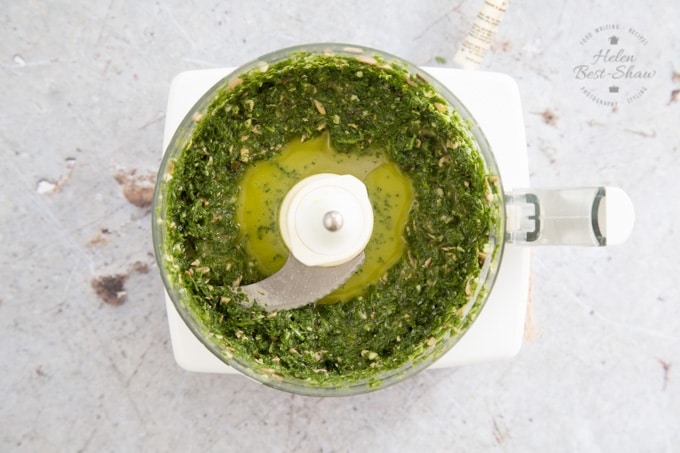 A food processor bowl of fresh carrot top pesto - viewed from above 