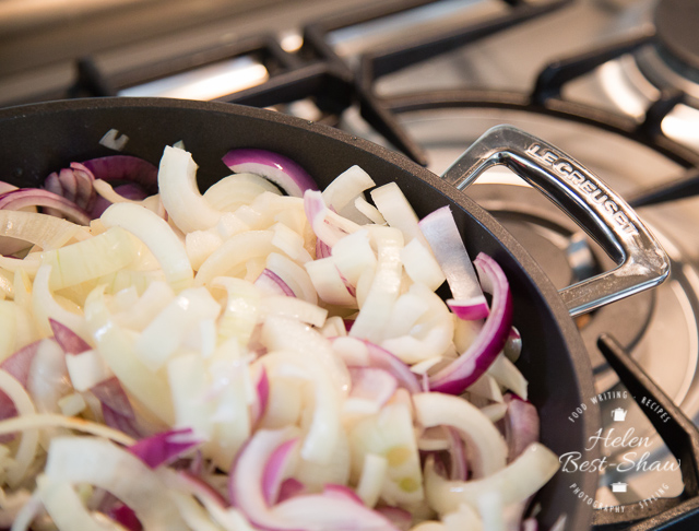 a pan full of sliced onions ready to be slowly cooked and reduced down to make caramelized onions