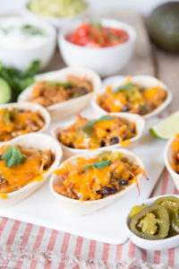 These mini tortilla shells filled with pulled chicken and blackbeans are perfect for a casual lunch with friends.