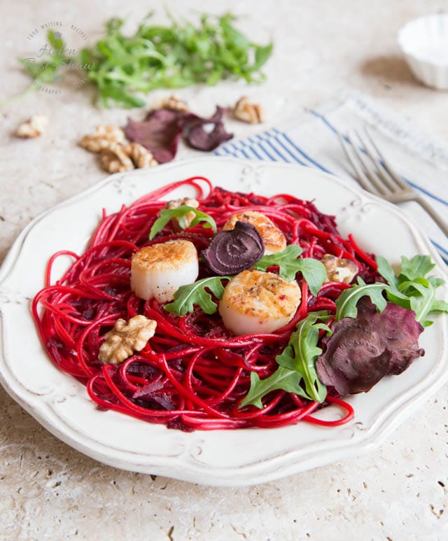 A bowl of spaghetti cooked with beetroot and served with scallops
