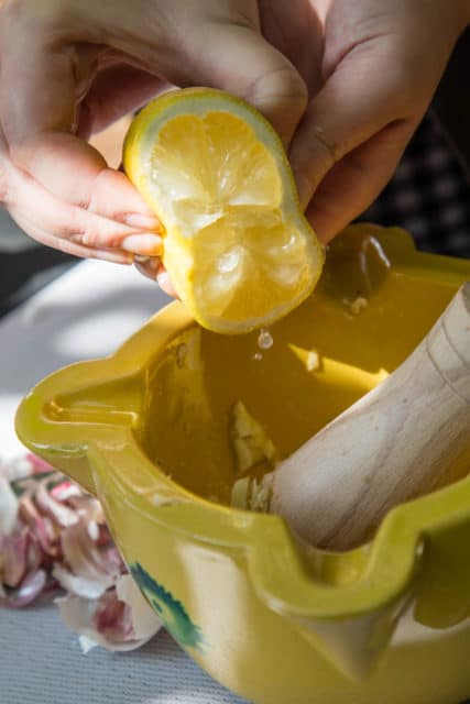How to make Catalan Allioli - add a squeeze of lemon to garlic and salt paste