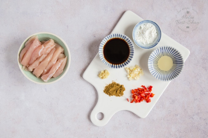Ingredients for easy chicken chow mein - strips of chicken breast, soy sauce, cornflour, rice wine, cumin, diced chili, ginger and garlic.