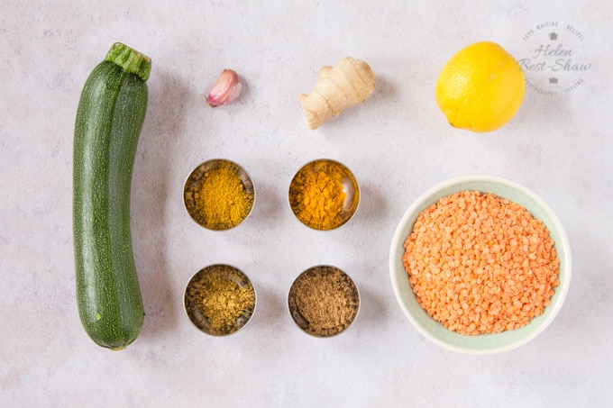 The ingredients for courgette daal, laid out: courgette, garlic, ginger, lemon, lentils, and spices.