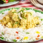 Healthy coronation chicken served on a rice salad, and garnished with sliced almonds and chopped chives.