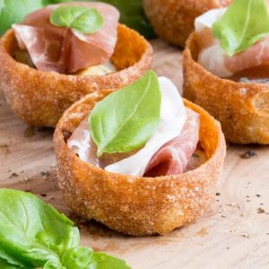 A close up of Parma ham canapes with sticky balsamic onion and gorgonzola cheese.
