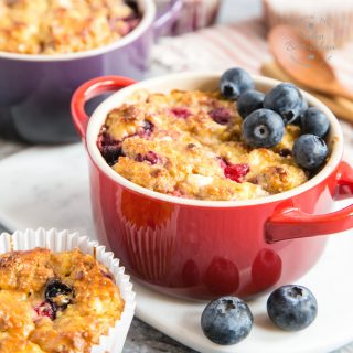 A close up of a an individual casserole dish full of breakfast protein baked oats, garnished with blueberies.