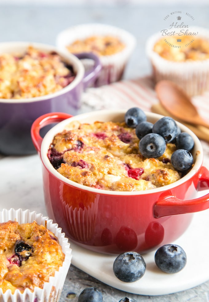 Individual ramekin dishes of breakfast protein baked oats, garnished with blueberries.