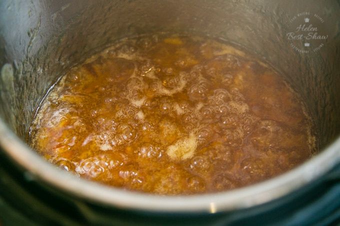 A picture of the inside of an Instant Pot electric pressure, showing the Seville orange marmalade boiling at the setting point.