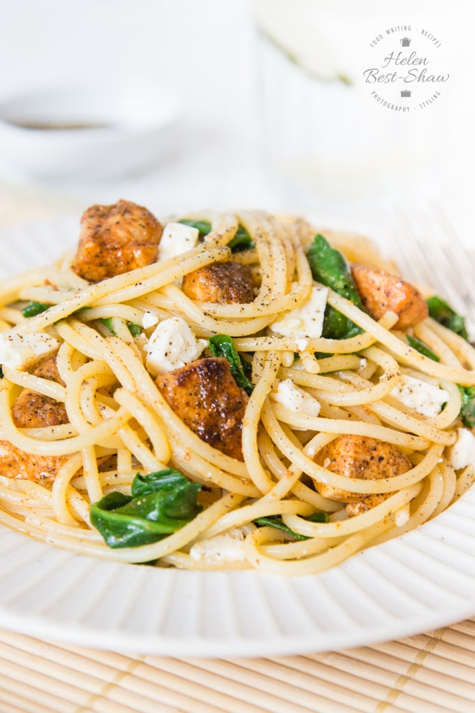 A close up of spaghetti, pieces of spicy garlic chicken, and spinach: our spicy garlic chicken pasta, the perfect week-night supper. 