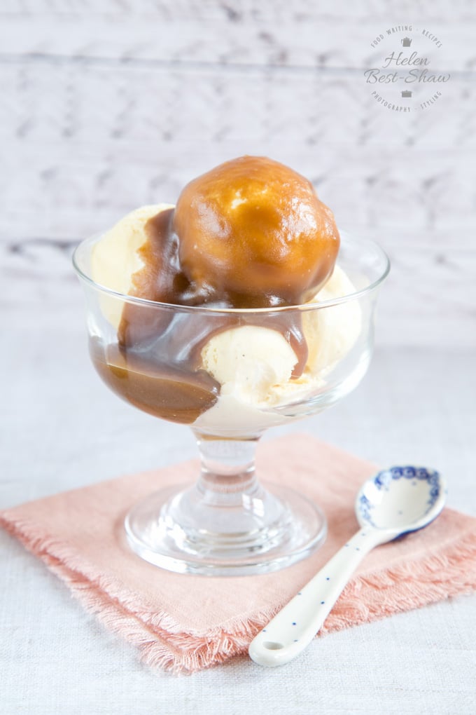 A glass bowl of 3 ingredient hot fudge sauce drizzled over scoops of ice cream