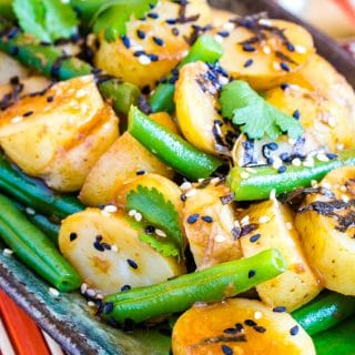 A close up of Japanese potato salad with French beans and black and white sesame seeds.