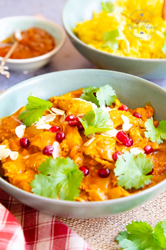 A close up on vibrant spiced leftover chicken curry, served in a green bowl.