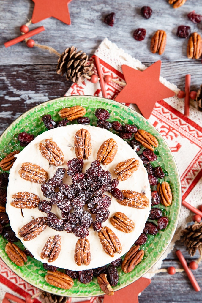 Top down view of no bake Christmas cheesecake, topped with pecans and cranberries.