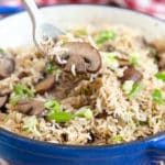 Taking a spoonful of mushroom rice pilau from the serving dish.