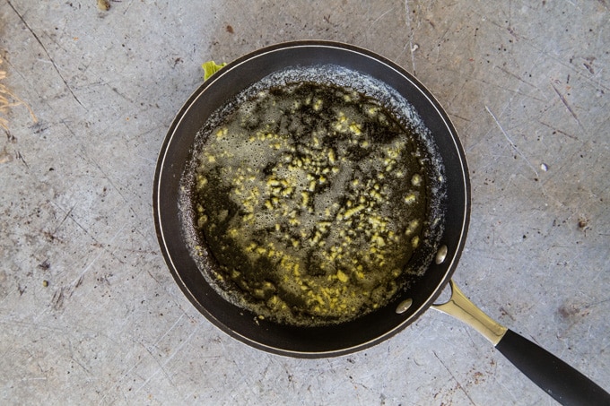 A frying pan showing the garlic being slowly cooked to release all the flavours without burning.