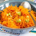 A close up of a blue bowl of easy carrot salad.