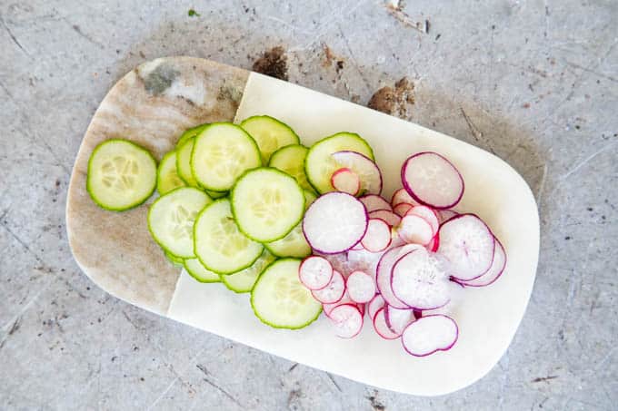 Sliced cucumber and radish on a marble board