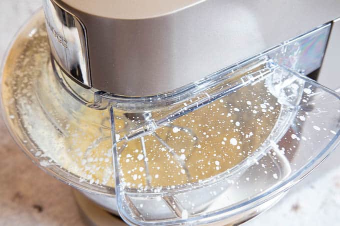 Making butter in a stand mixer - the splatterguard covered in splashes of cream.