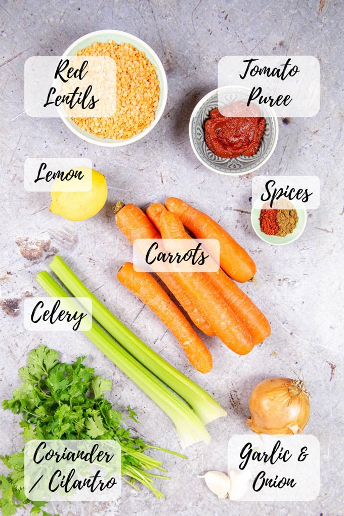 Annotated top down shot of ingredients for carrot and lentil soup.