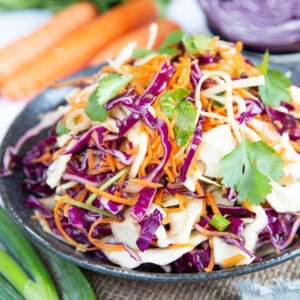 Close up of vibrant red cabbage, carrot and crispy white cabbage coleslaw.
