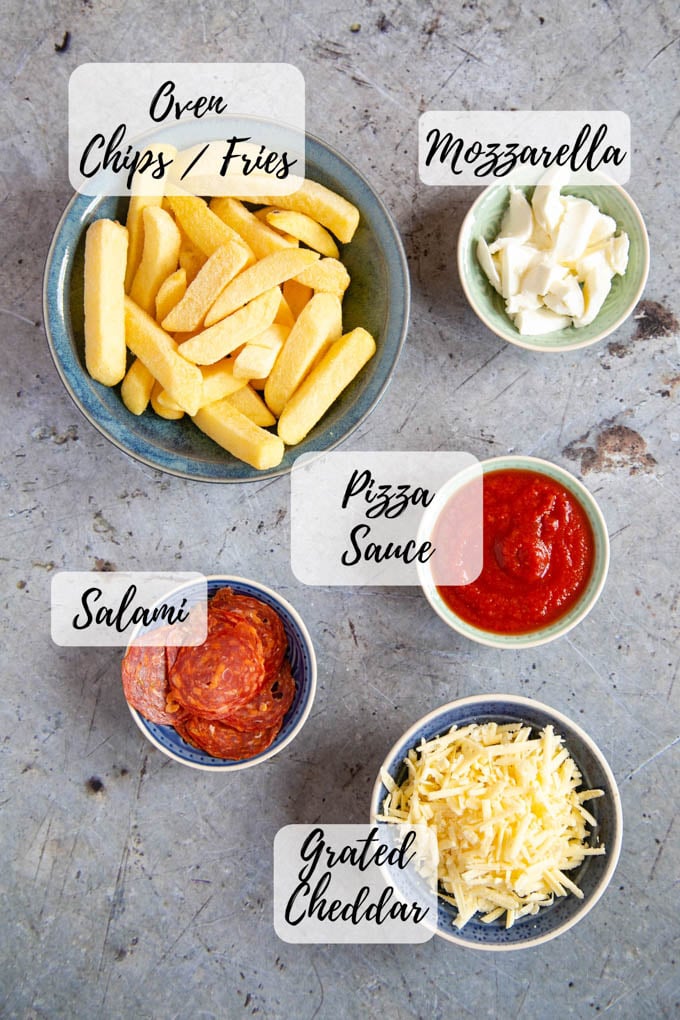The ingredients for pizza fries - oven fries, mozzarella, pizza sauce, sliced salami, grated cheddar