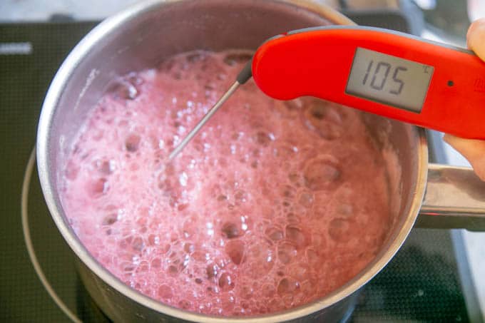 Jam boiling in a saucepan. A digital thermometer reads 105°C.