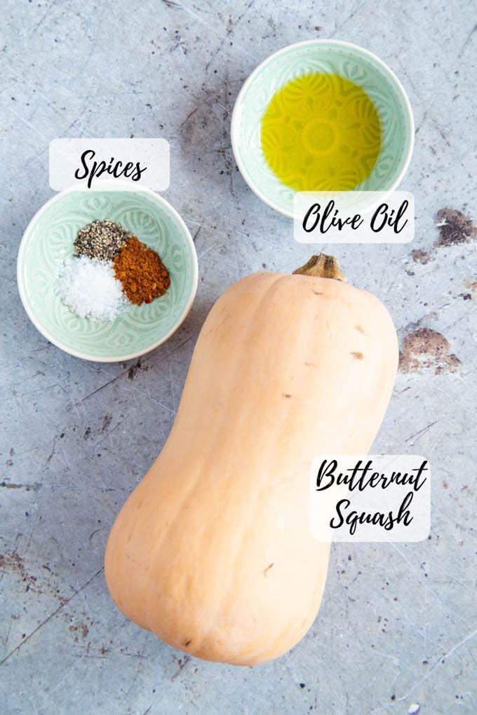 An annotated top down picture of butternut squash, oil and spices: ingredients ready to cook.