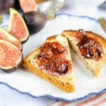 A close up of two pieces of toast spread with butter and fig jam