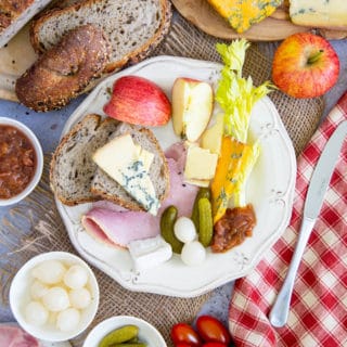 Top down picture of a plate of delicious ploughmans lunch, with bread, cheese and ham.