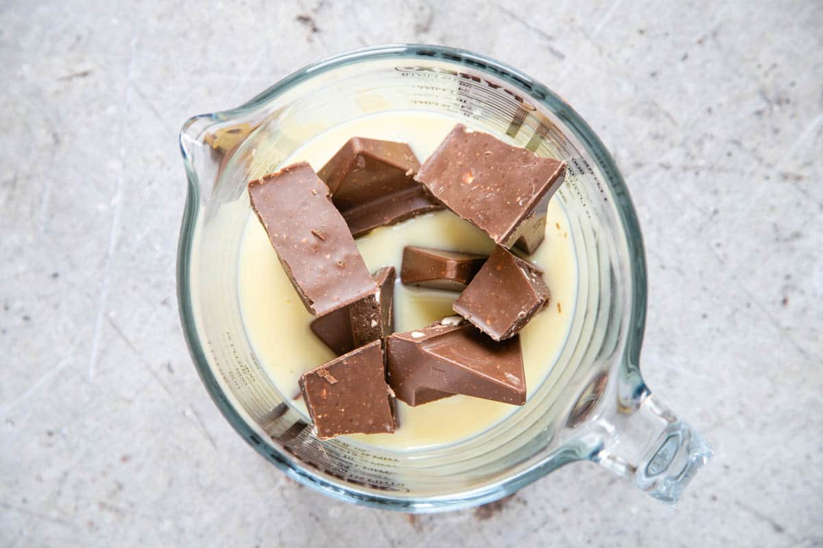 Top down pic of Toblerone chunks in a jug with condensed milk.