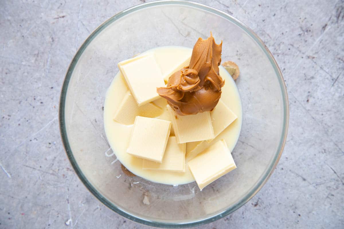 From above: condensed milk, white chocolate, and biscoff spread in a glass bowl.