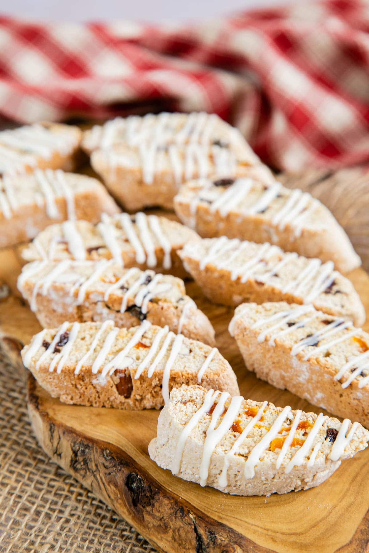 Drizzle glazed biscotti arranged on a wooden board, ready to serve with coffee.