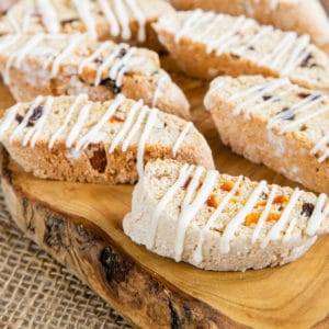 Close up of drizzle glazed biscotti on an olive wood board.