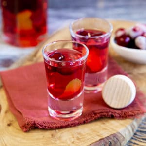 Pretty shot glasses filled with cranberry red vodka, a pretty and tempting holiday treat.