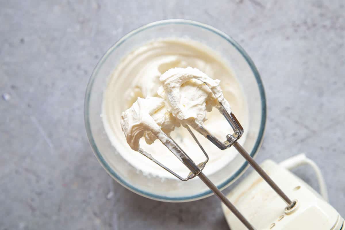 The whipped cream holds stiff peaks and sticks to the beaters.