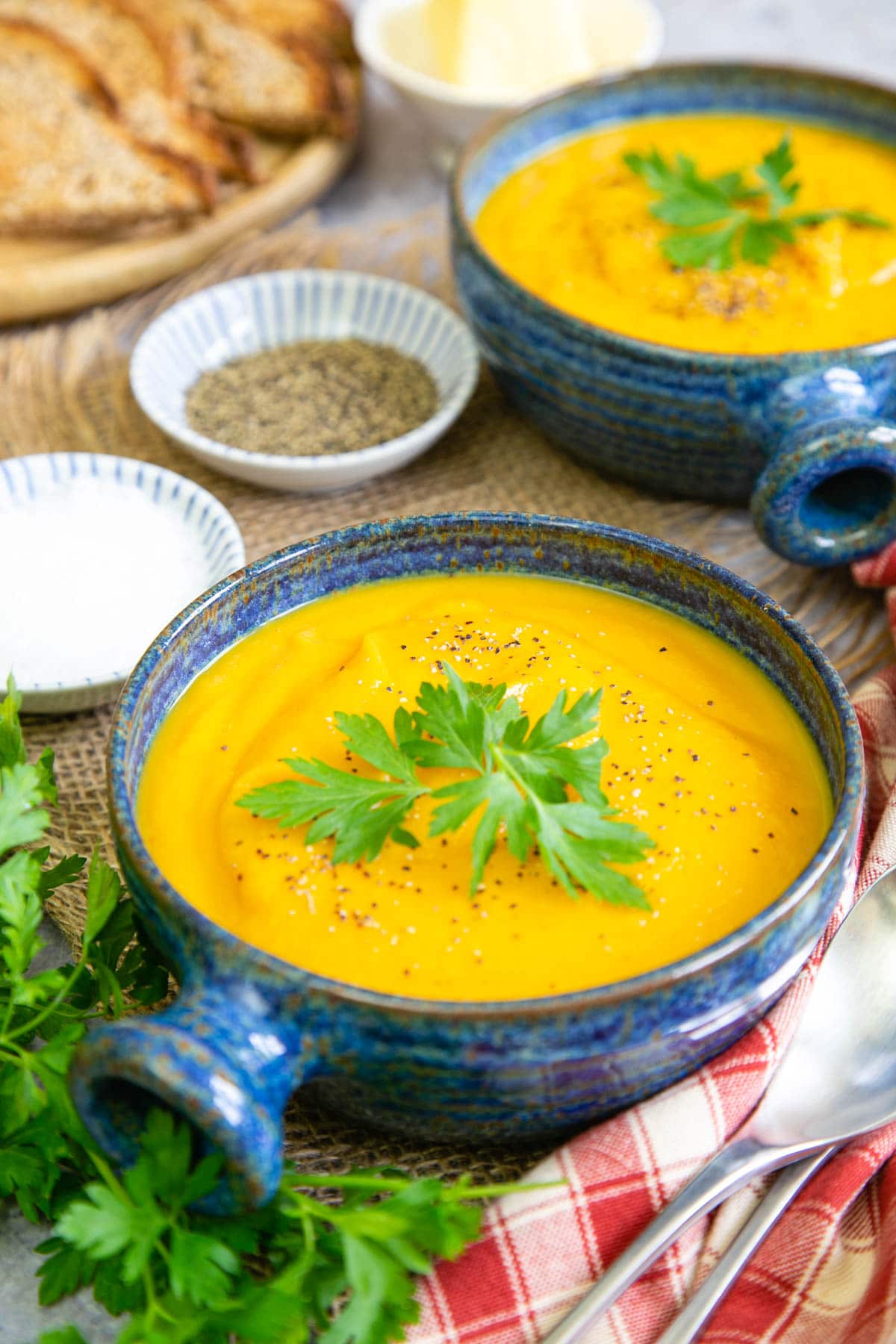 An inviting bowl of golden parsnip and carrot soup, garnished with fresh parsley