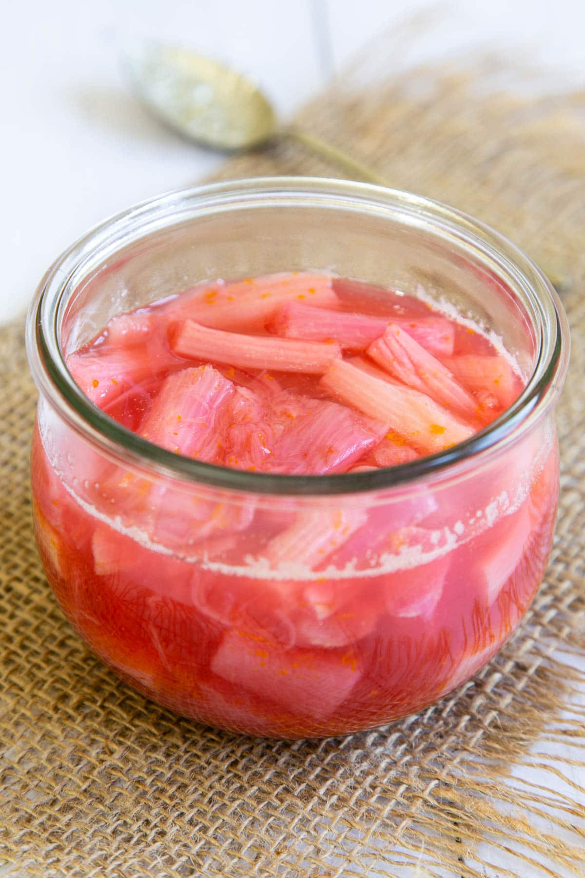 The pretty pink tones of stewed early rhubarb are shown off in all their glory in a glass serving dish.