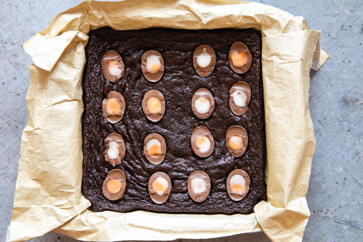 Gently press the eggs into the partially cooked brownie and return to the oven to finish.