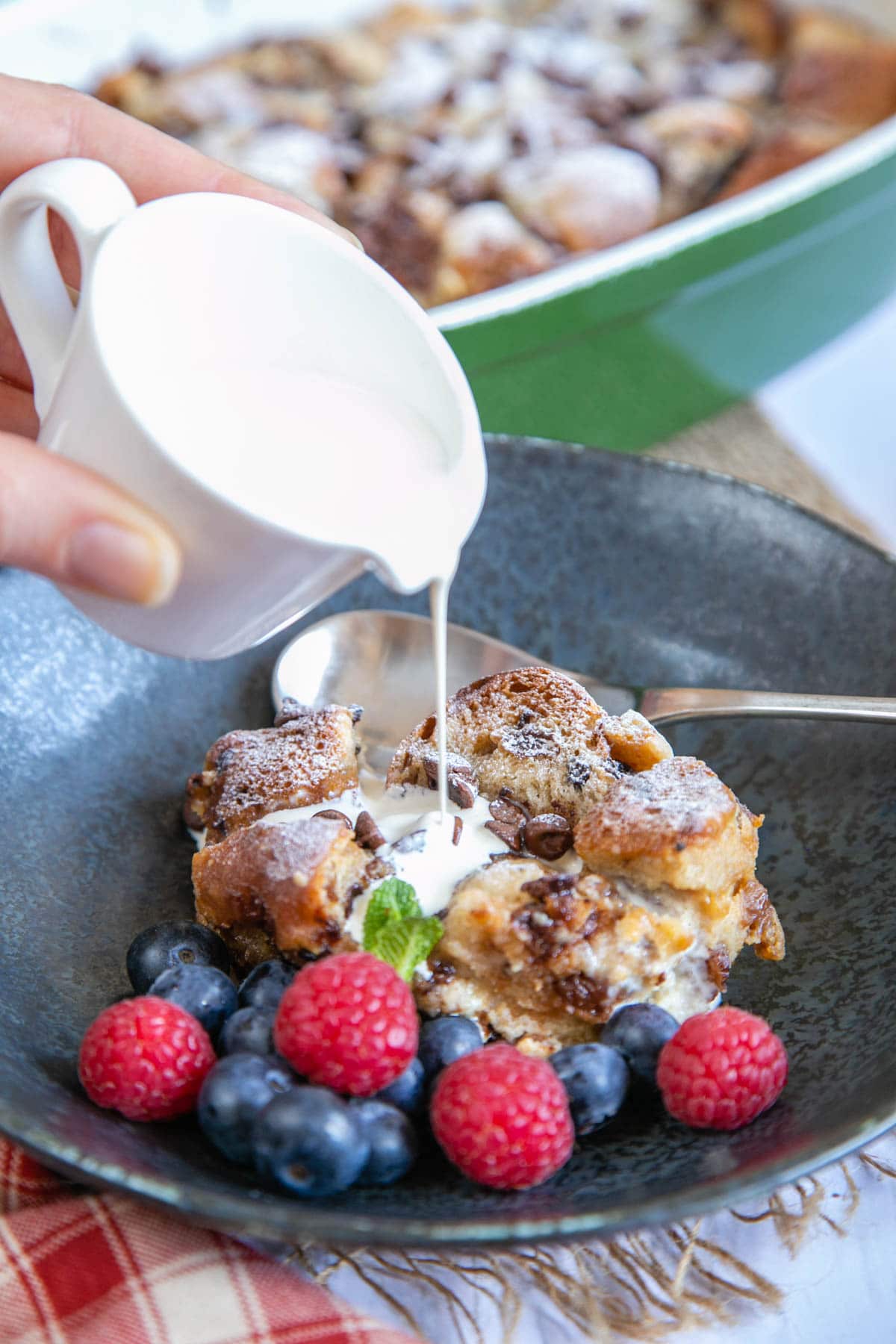 Hot cross bun bread and butter pudding, served with fresh berries and a drizzle of cream.