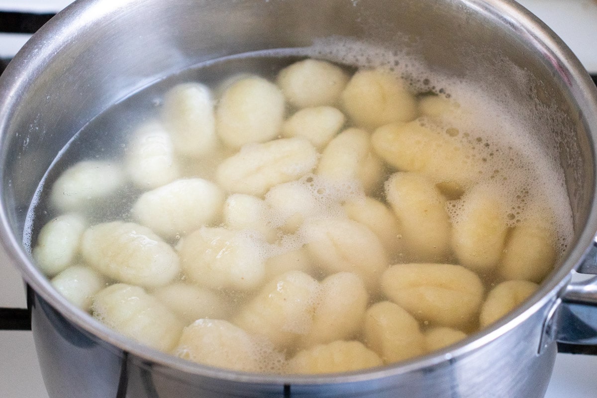 Simmering the gnocchi in a pan of salted water. When ready, they rise to the top.