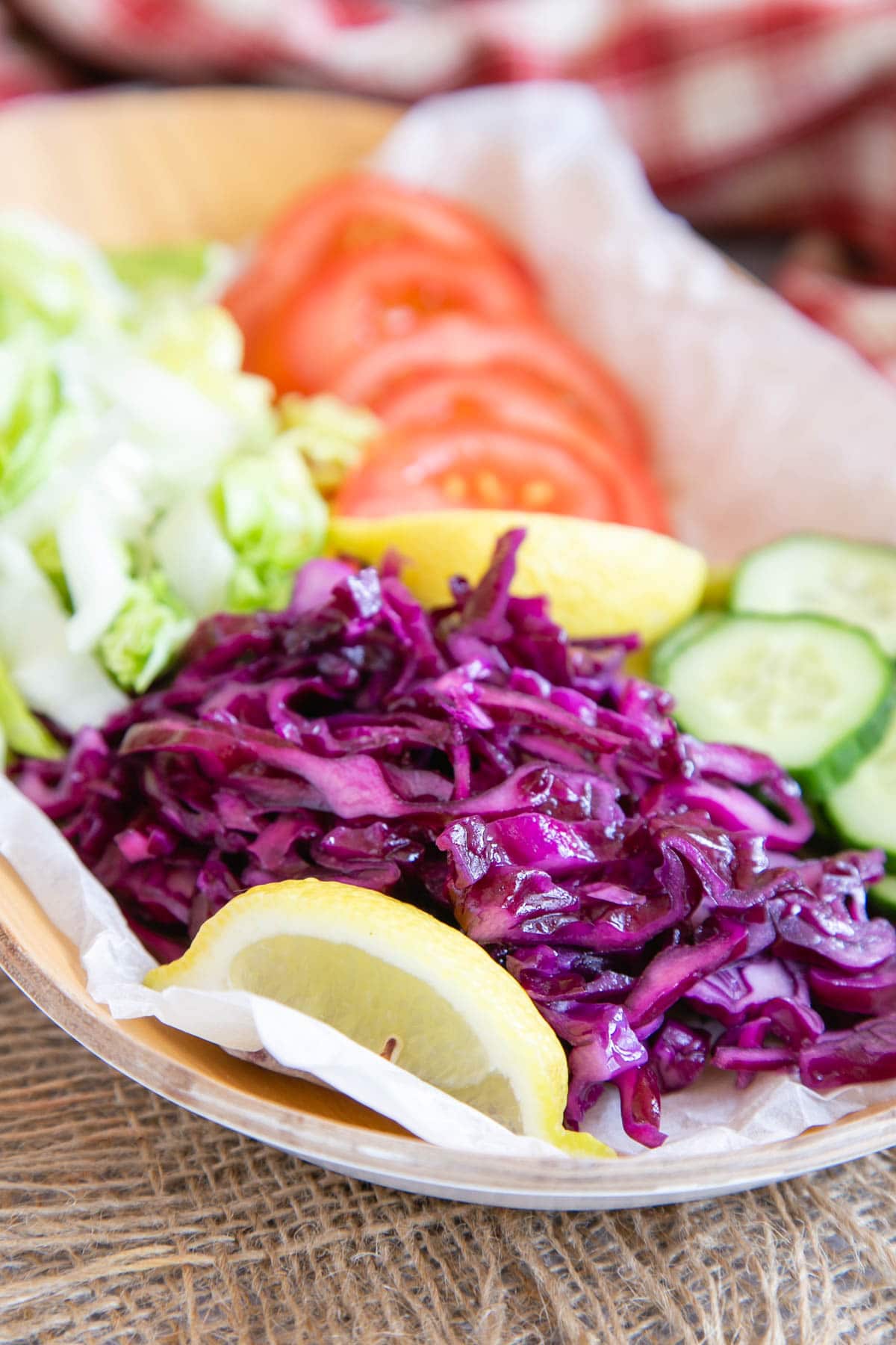 Kebab shop salad laid out on a platter - fresh and bright and tempting with red cabbage, greed and cucumber, tomatoes and lemon wedges
