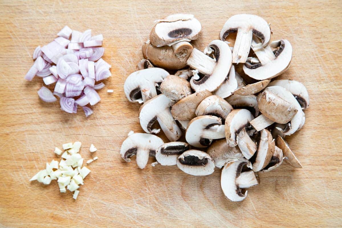 The vegetables prepared: finely chopped shallot and garlic, sliced mushrooms ready to cook