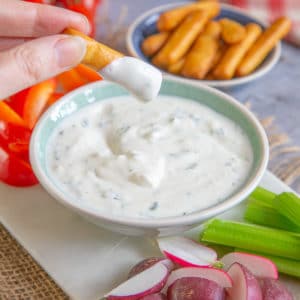 Scooping garlic onion dip with a savoury snack.