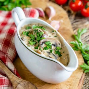 A sauce boat of rich, creamy Diane sauce, garnished with fresh parsley.